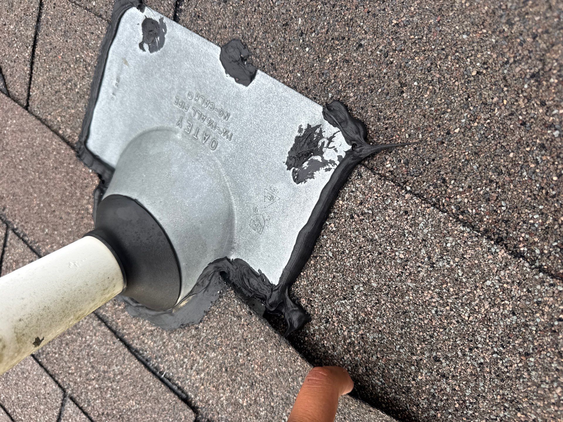Close-up of Oatey pipe flashing properly sealed on shingle roof