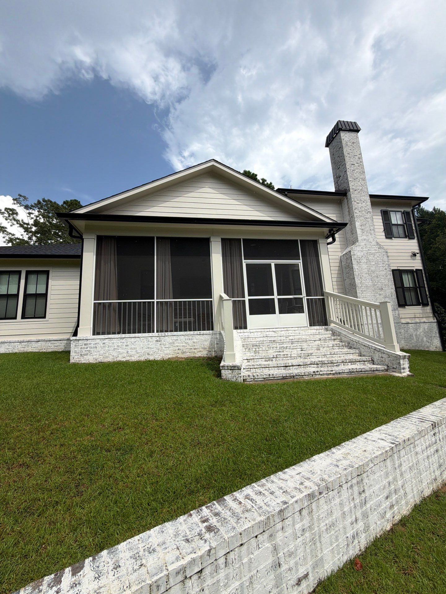 Screened porch with a gable roof and white-washed brick steps built by GD Construction in Biloxi, Mississippi
