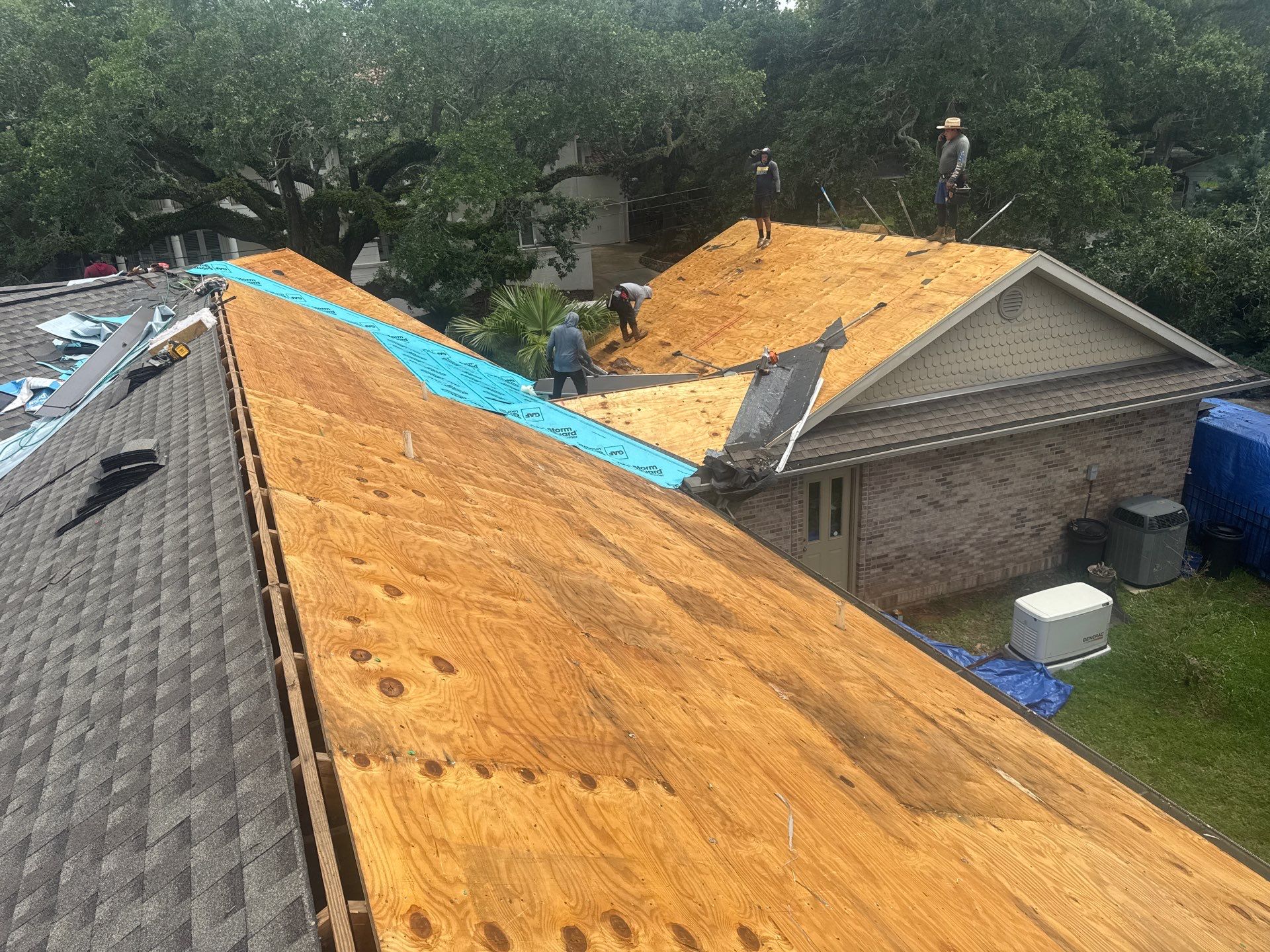 Full plywood decking replacement across multiple roof planes with crew working