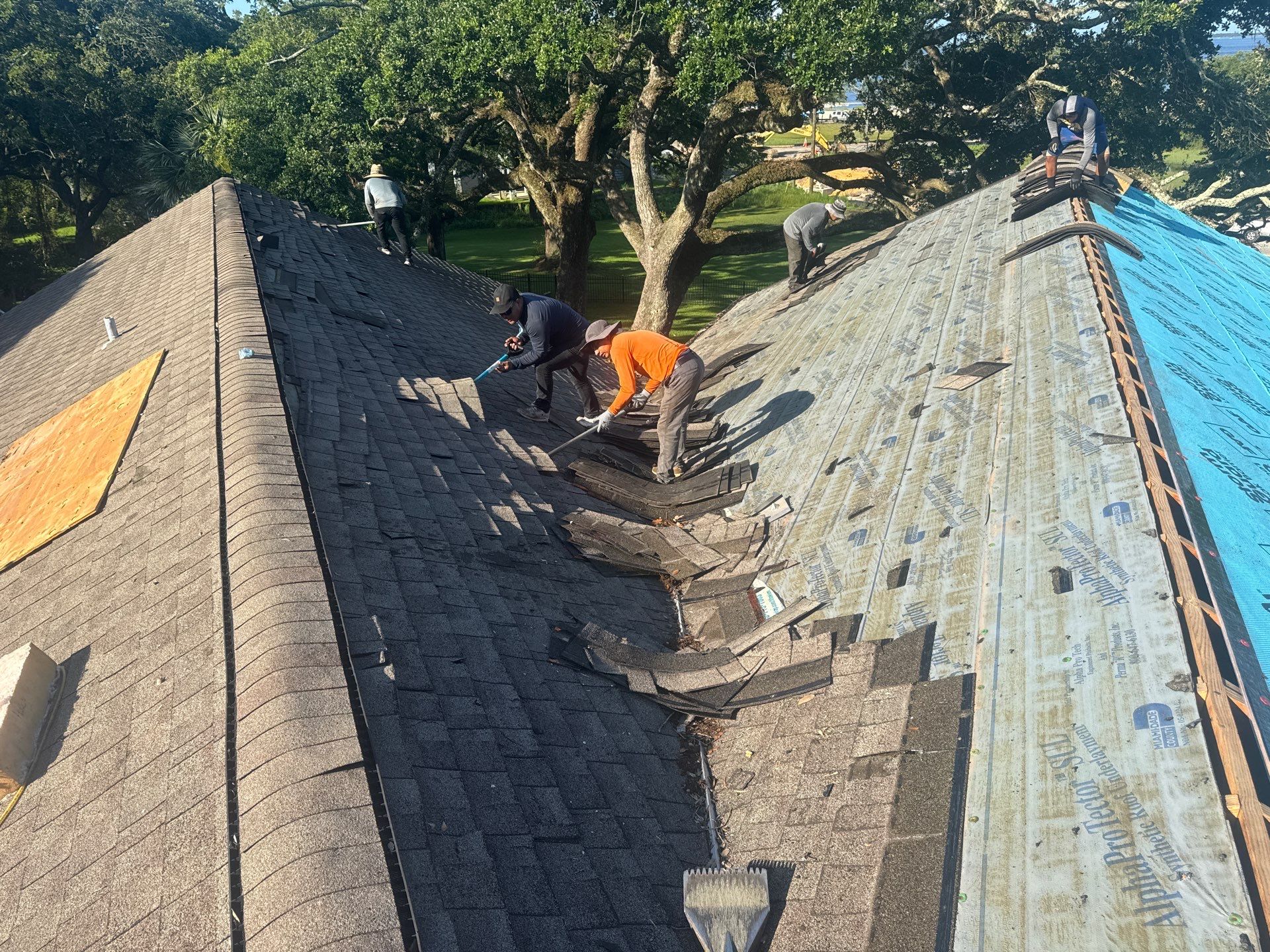 Roofing crew tearing off old shingles down to decking