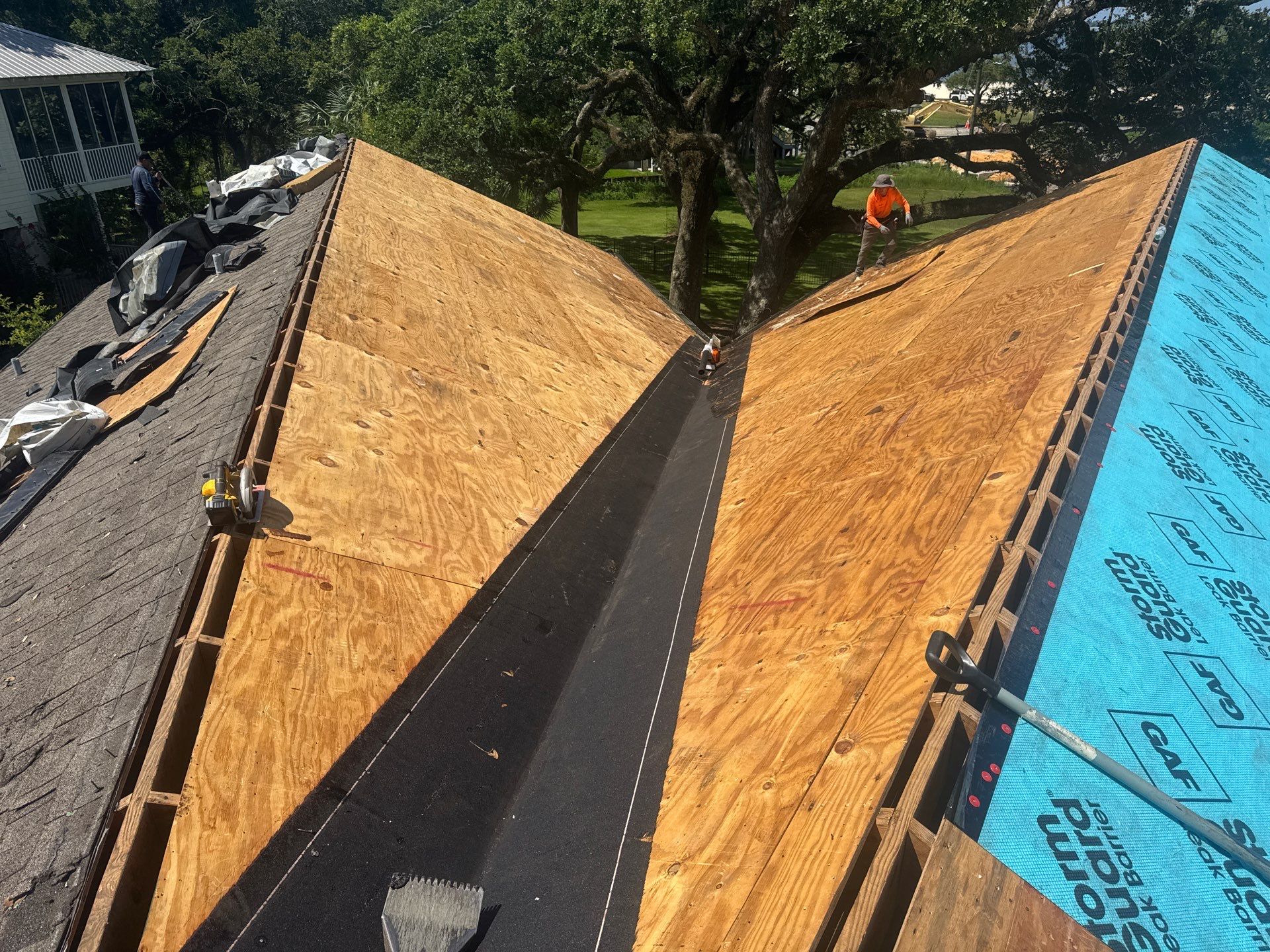 Fresh plywood decking with ridge vent cut prepped for underlayment