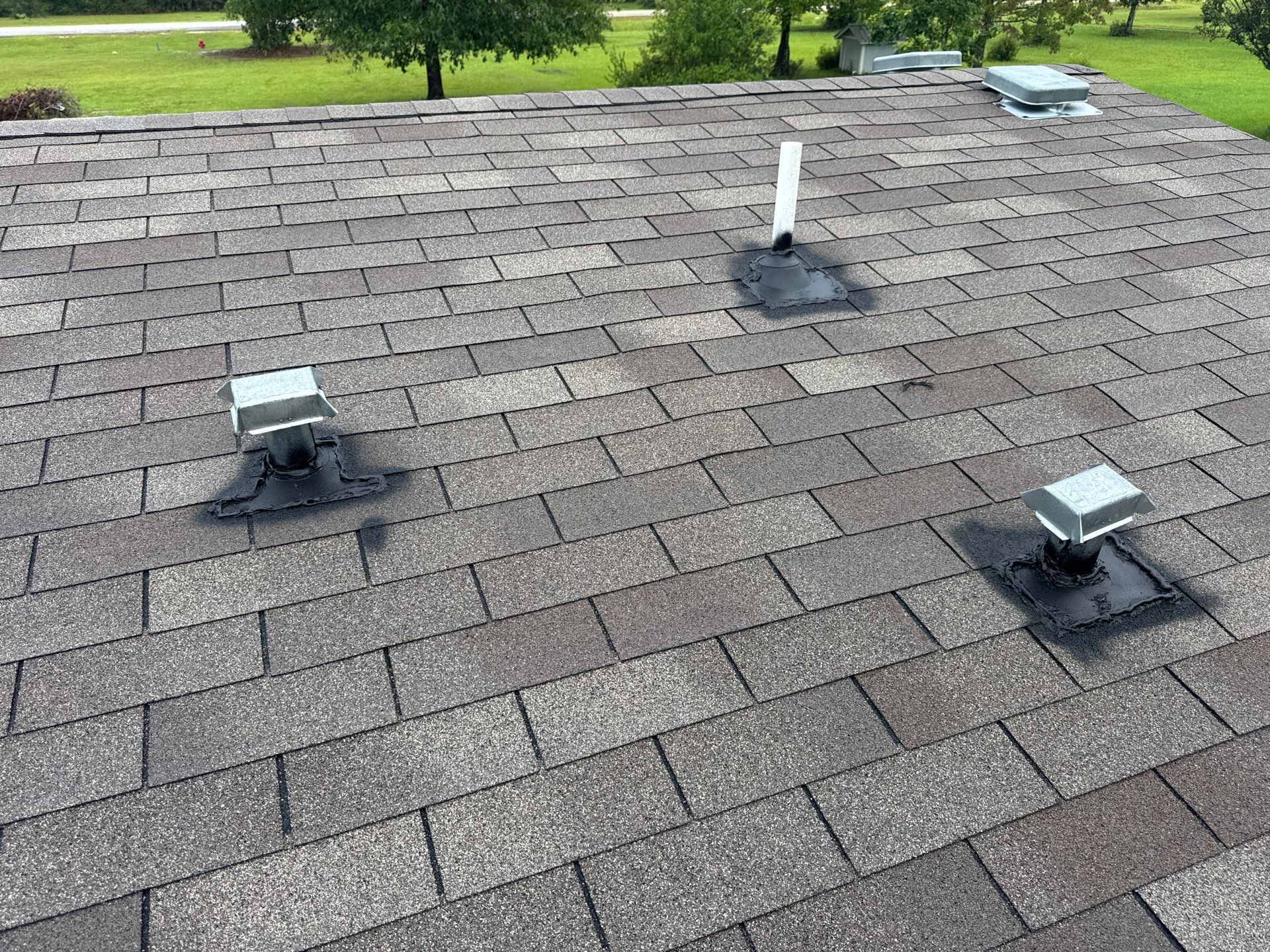 Shingle roof with new pipe boot and box vent flashings sealed in