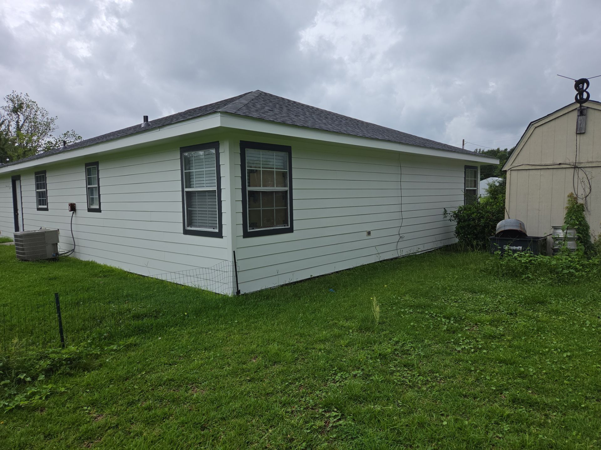 Home exterior with fresh light siding and black window trim