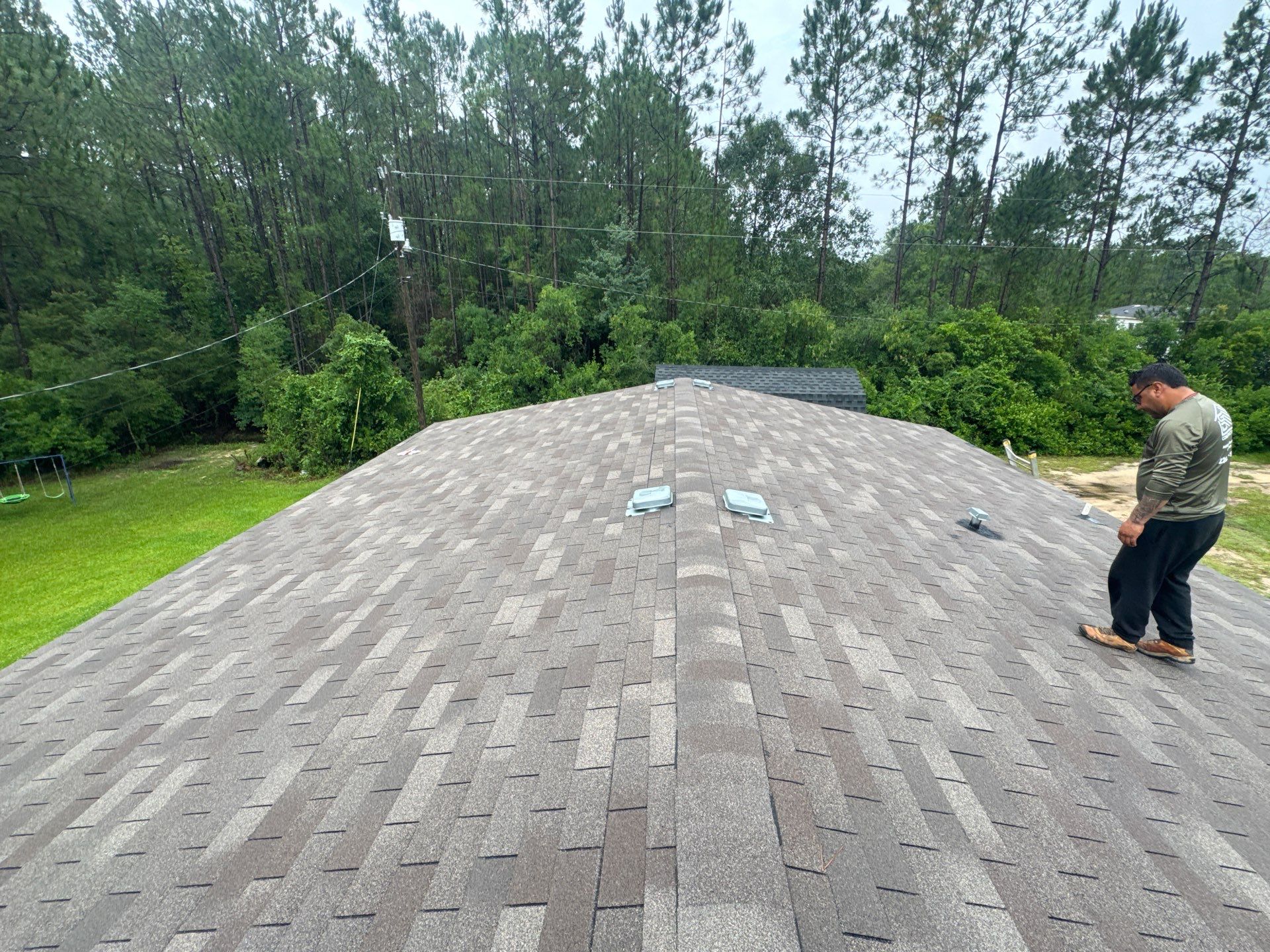 Long shingle roof ridge with crew member completing the install
