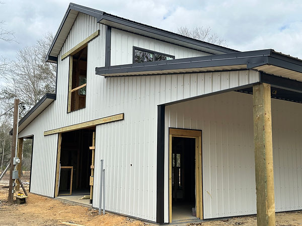 Large-scale metal building with white vertical panels and covered porch
