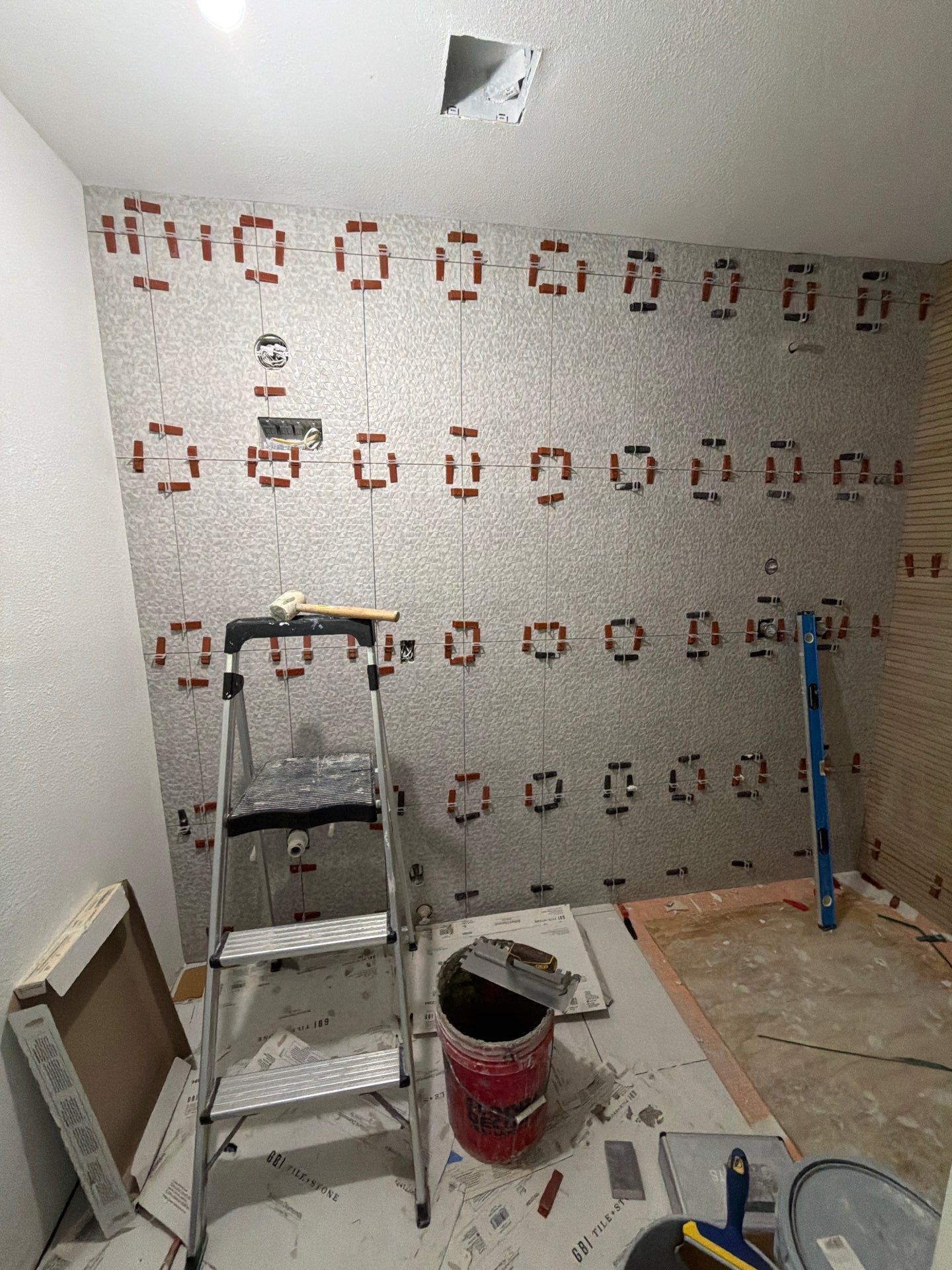 Floor-to-ceiling stone-look tile feature wall in progress