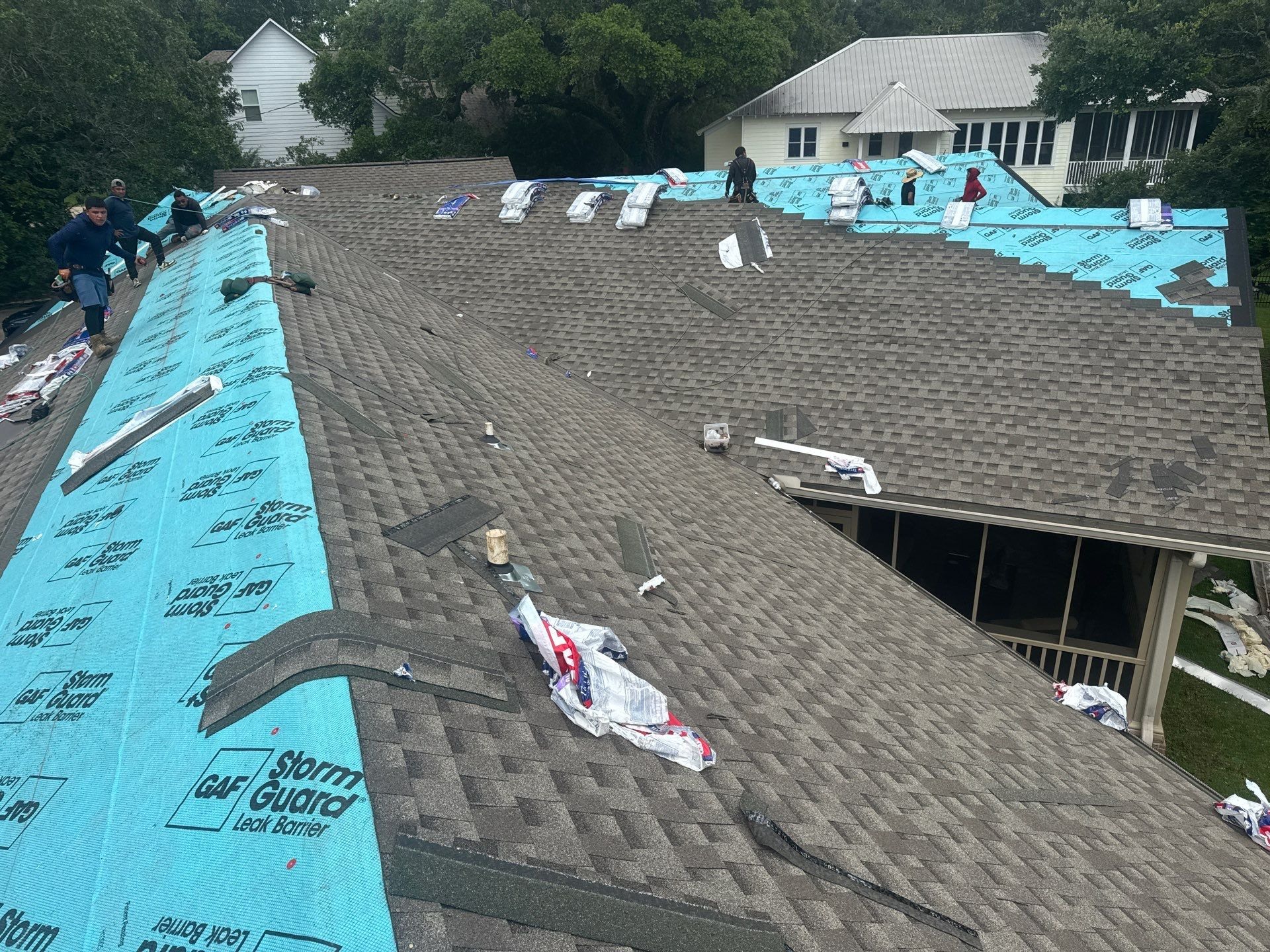GD Construction crew working on both slopes of a shingle re-roof in progress