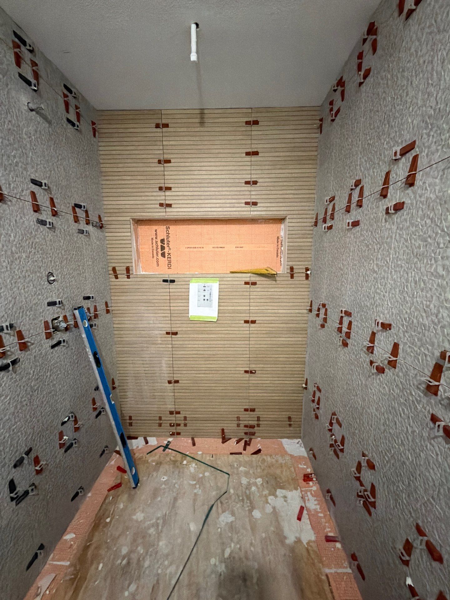 Walk-in shower with large-format tile, accent wall, and built-in niche